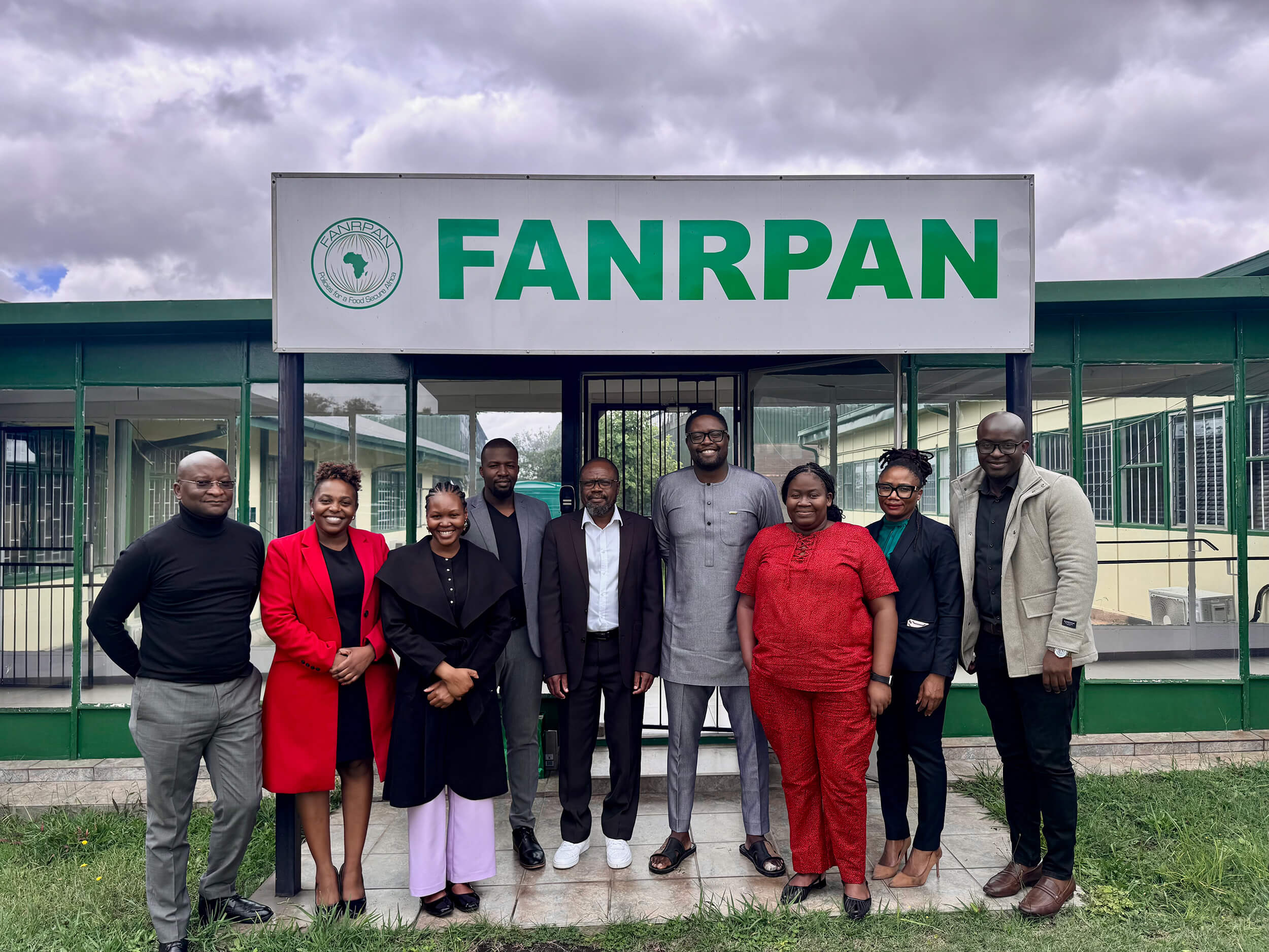 A group of professionals stands outside the FANRPAN headquarters building for a team photograph. The gathering includes representatives and partners posed beneath the organisation’s signage, reflecting collaboration and engagement around regional food security, agriculture, and development initiatives in Africa.